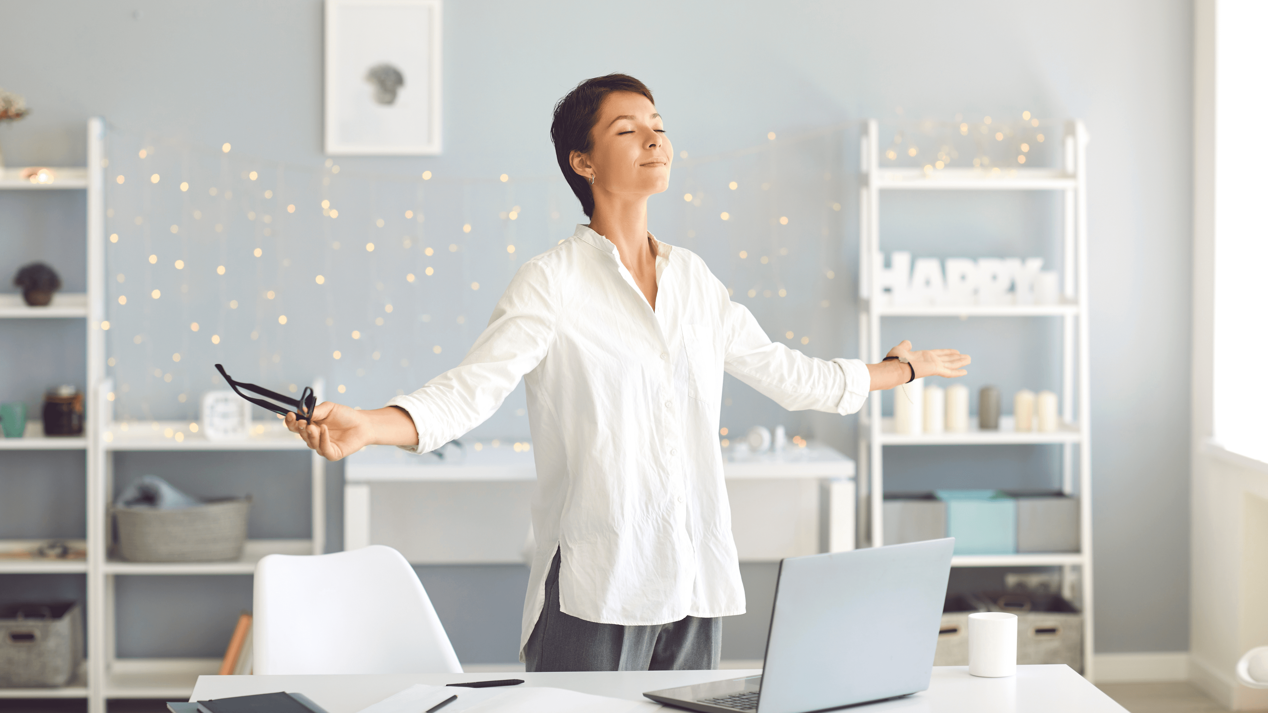 women in a office setting with arms extended and with a peaceful face